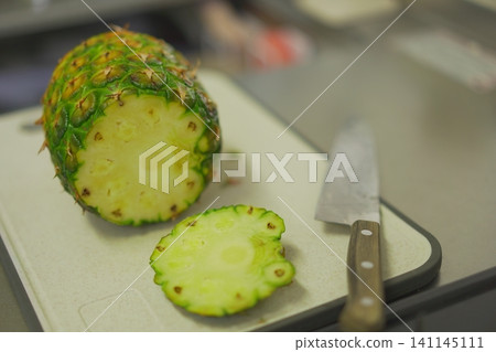 Pineapple being cut in the kitchen Pineapple being cut in the kitchen 141145111