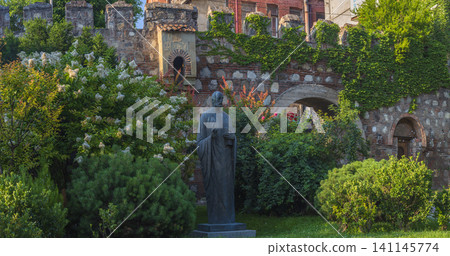 Monument near ancient Tbilisi city fortress wall covered in green ivy Monument near ancient Tbilisi city fortress wall covered in green ivy 141145774