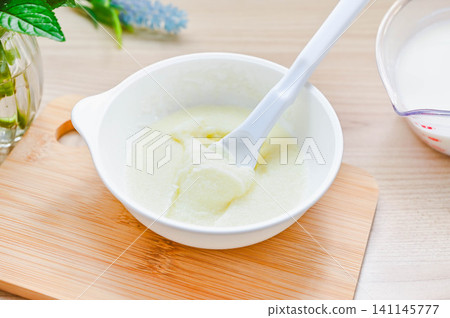 將明膠粉浸泡在牛奶中的過程。 將明膠粉浸泡在牛奶中的過程。 141145777