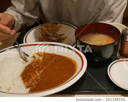 A man eating a curry set (face not shown) A man eating a curry set (face not shown) 141149359