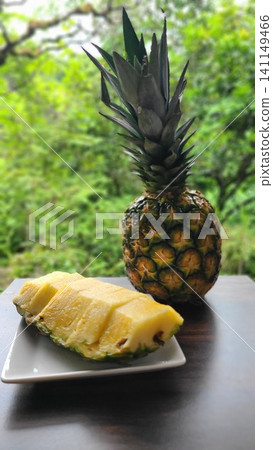 Sliced pineapple and whole pineapple served on a plate Sliced pineapple and whole pineapple served on a plate 141149466
