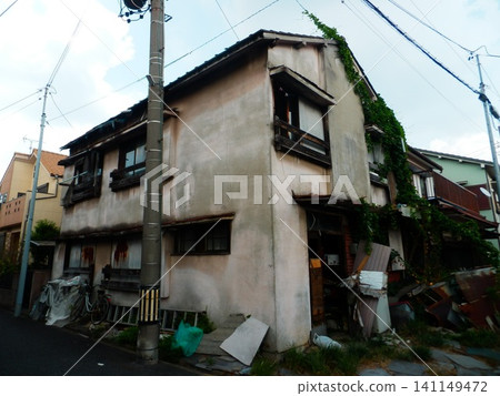 A dilapidated wooden house standing in an alleyway A dilapidated wooden house standing in an alleyway 141149472