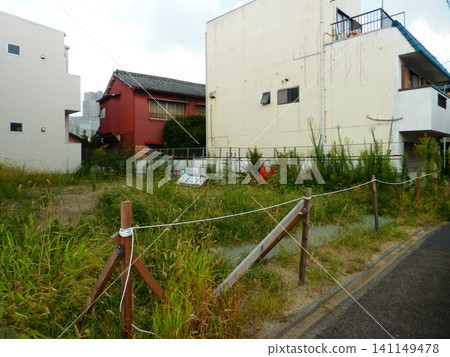 住宅區內一塊雜草叢生的空地。 住宅區內一塊雜草叢生的空地。 141149478