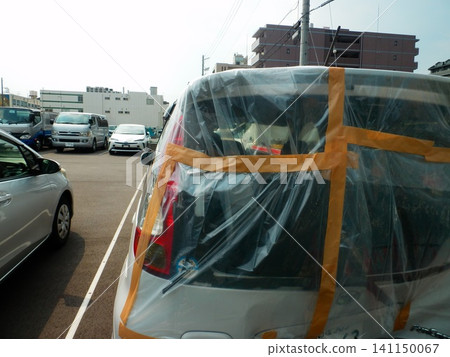 Cars covered with plastic sheeting and tape Cars covered with plastic sheeting and tape 141150067