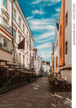 Empty Cobblestone Street with Outdoor Cafe Terraces in Tallinn 141150395