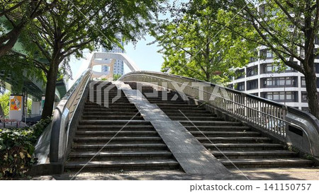The Yaba Bridge is a pedestrian bridge spanning Otsu Street in Nagoya, surrounded by lush green trees. The Yaba Bridge is a pedestrian bridge spanning Otsu Street in Nagoya, surrounded by lush green trees. 141150757