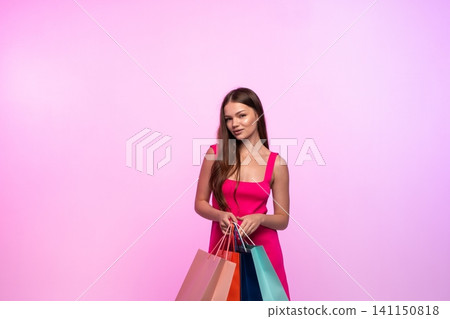Young woman confidently posing with several shopping bags, enjoying a successful retail therapy session 141150818
