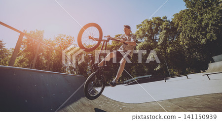 Bmx rider performing tricks at skatepark. Bmx rider performing tricks at skatepark. 141150939