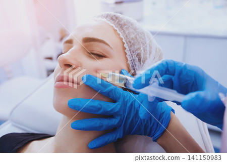 Beautician and the patient in the clinic of aesthetic medicine. Beautician and the patient in the clinic of aesthetic medicine. 141150983