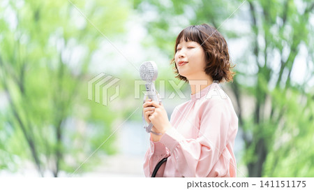 Woman using a handheld fan to cool herself down - heatstroke prevention Woman using a handheld fan to cool herself down - heatstroke prevention 141151175
