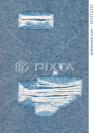 Close up of ripped blue denim fabric with frayed threads and distressed texture Close up of ripped blue denim fabric with frayed threads and distressed texture 141151255