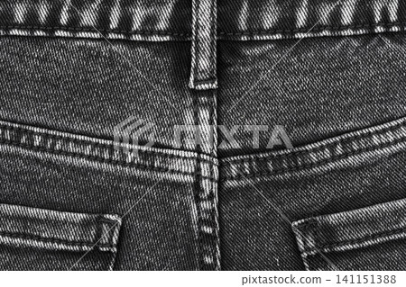 Black denim jeans texture close up. Detail of back pocket, seam and belt loop on dark fabric Black denim jeans texture close up. Detail of back pocket, seam and belt loop on dark fabric 141151388