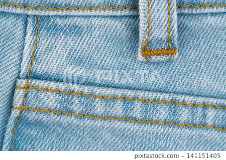 Blue jeans denim texture with yellow stitching and belt loop detail Blue jeans denim texture with yellow stitching and belt loop detail 141151405