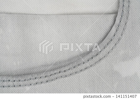 Gray denim fabric texture with visible stitching detail top view Gray denim fabric texture with visible stitching detail top view 141151407