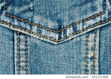 Close up view of blue denim pocket with orange stitching. Detailed texture of cotton fabric on jeans jacket. Clothes material background for fashion design and textile industry concept Close up view of blue denim pocket with orange stitching. Detailed texture of cotton fabric on jeans jacket. Clothes material background for fashion design and textile industry concept 141151408