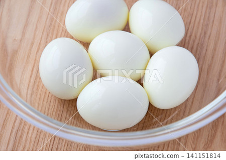 Peeled hard-boiled eggs in a glass bowl 141151814