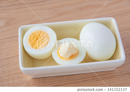 Hard-boiled eggs cut in half and placed in a bowl Hard-boiled eggs cut in half and placed in a bowl 141152137
