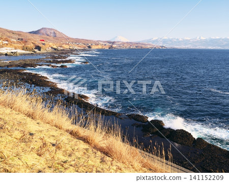 Winter in Hokkaido's Shakotan Peninsula: Kabuto Senjojiki Rock on the Japan Sea Oiwake Soran Line; a view of Mount Yotei from the parking lot. Winter in Hokkaido's Shakotan Peninsula: Kabuto Senjojiki Rock on the Japan Sea Oiwake Soran Line; a view of Mount Yotei from the parking lot. 141152209