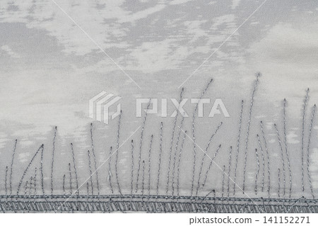 Embroidered grass pattern on textured fabric with soft gray tones Embroidered grass pattern on textured fabric with soft gray tones 141152271