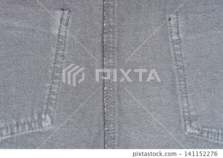 Gray denim fabric closeup with visible stitching and texture Gray denim fabric closeup with visible stitching and texture 141152276