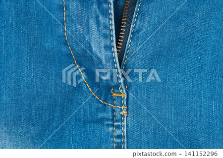 Blue denim texture with brass zipper and golden thread detail Blue denim texture with brass zipper and golden thread detail 141152296