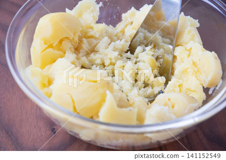 Mash the steamed potatoes to make mashed potatoes. Mash the steamed potatoes to make mashed potatoes. 141152549