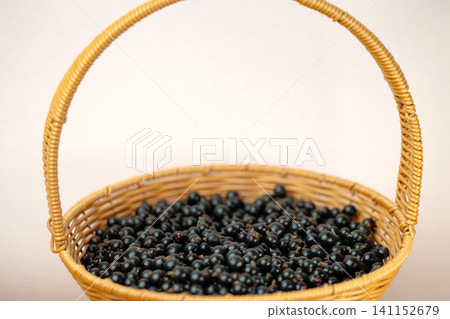 Ripe blackcurrants in wicker basket Ripe blackcurrants in wicker basket 141152679