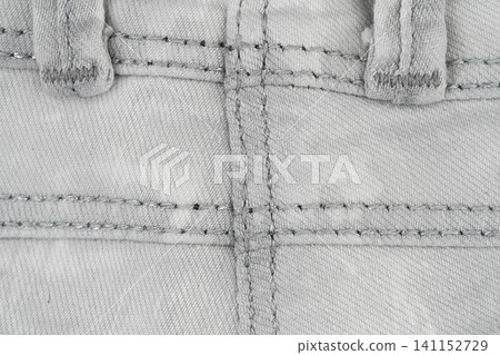 Denim fabric texture with detailed stitching and buttonholes top view Denim fabric texture with detailed stitching and buttonholes top view 141152729