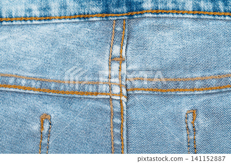Close up of blue denim jeans with orange stitching and pocket details Close up of blue denim jeans with orange stitching and pocket details 141152887