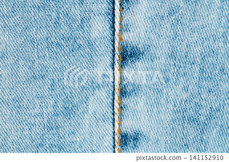 Blue denim jeans texture with orange stitching. Detailed macro close up of fabric weave and vertical seam. Clothing material background for fashion design and textile industry projects Blue denim jeans texture with orange stitching. Detailed macro close up of fabric weave and vertical seam. Clothing material background for fashion design and textile industry projects 141152910