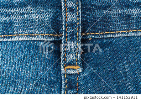Blue denim jeans texture with belt loop and orange stitching macro detail Blue denim jeans texture with belt loop and orange stitching macro detail 141152911