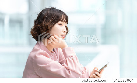 一位正在用智慧型手機思考的女性/女商人 一位正在用智慧型手機思考的女性/女商人 141153004