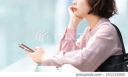 一位正在用智慧型手機思考的女性/女商人 一位正在用智慧型手機思考的女性/女商人 141153005
