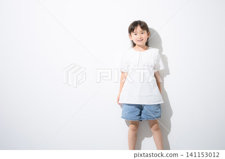 A smiling Japanese girl standing in front of a white background; full-body portrait and copy space. A smiling Japanese girl standing in front of a white background; full-body portrait and copy space. 141153012