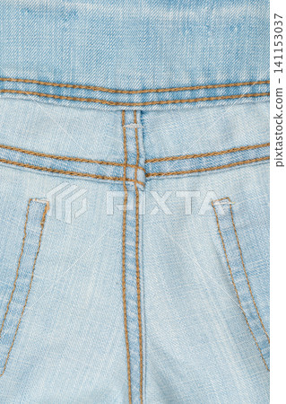 Closeup of light blue denim fabric with brown stitching and pocket details Closeup of light blue denim fabric with brown stitching and pocket details 141153037