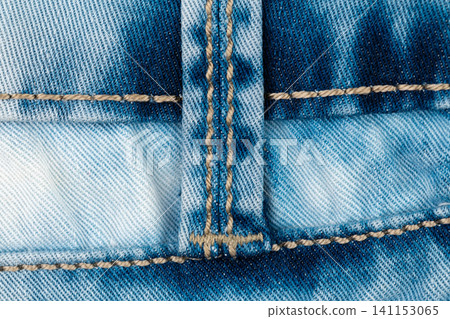 Macro detail of blue denim jeans textile. Close up of garment fabric with textured pattern, stitching and seam. Casual clothing material background, fashion industry design element 141153065