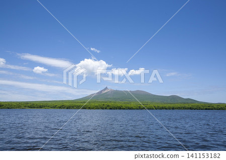 A magnificent volcanic island viewed from the sea, a scenic spot surrounded by lush nature. A magnificent volcanic island viewed from the sea, a scenic spot surrounded by lush nature. 141153182