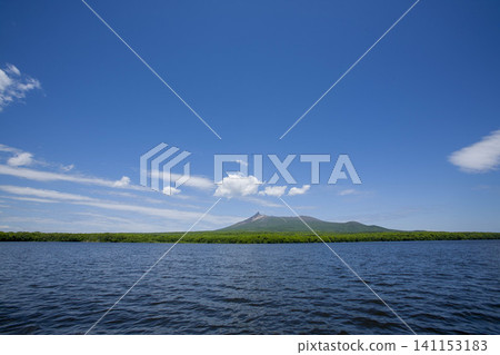 A breathtaking view of lush green mountains and volcanoes from the sea, against a cloudless blue sky. A breathtaking view of lush green mountains and volcanoes from the sea, against a cloudless blue sky. 141153183