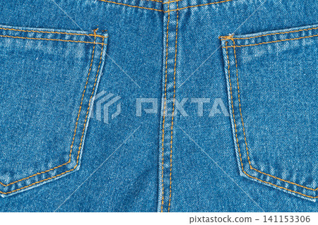 Blue denim jeans texture with back pockets and orange stitching closeup 141153306