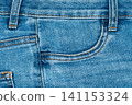 Blue denim jeans texture with front pocket and orange stitching detail 141153324