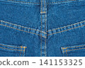 Blue jeans back pocket and yoke seam detail. Denim fabric texture background with yellow stitching 141153325