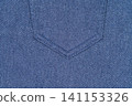 Blue denim fabric texture with seam detail. Close up of jeans material background 141153326