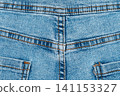 Blue denim jeans texture with orange stitching detail, close up of back seam and yoke 141153327
