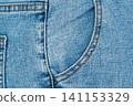 Blue denim jeans front pocket texture with orange stitching 141153329