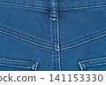 Close up of blue denim jeans fabric with seams and belt loop 141153330