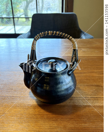 A black ceramic teapot (dobin) on the table - Japan A black ceramic teapot (dobin) on the table - Japan 141153598