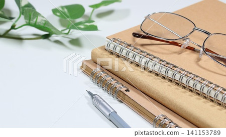 Study/reading workspace with notebook and glasses, and copy space. Study/reading workspace with notebook and glasses, and copy space. 141153789