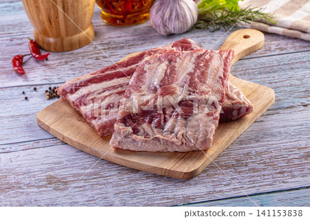 Raw pork spare ribs with seasonings on a rustic wooden table 141153838