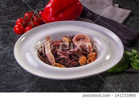Black spaghetti with squid and mussels on white plate Black spaghetti with squid and mussels on white plate 141153968