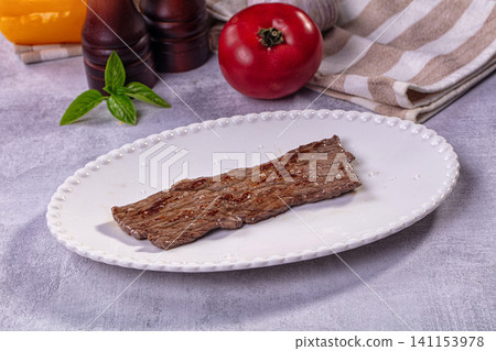 Grilled beef steak on white plate with tomato and basil Grilled beef steak on white plate with tomato and basil 141153978